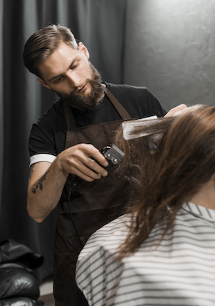 male barber trimming customer s hair