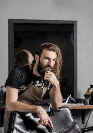 portrait male barber with electric trimmer